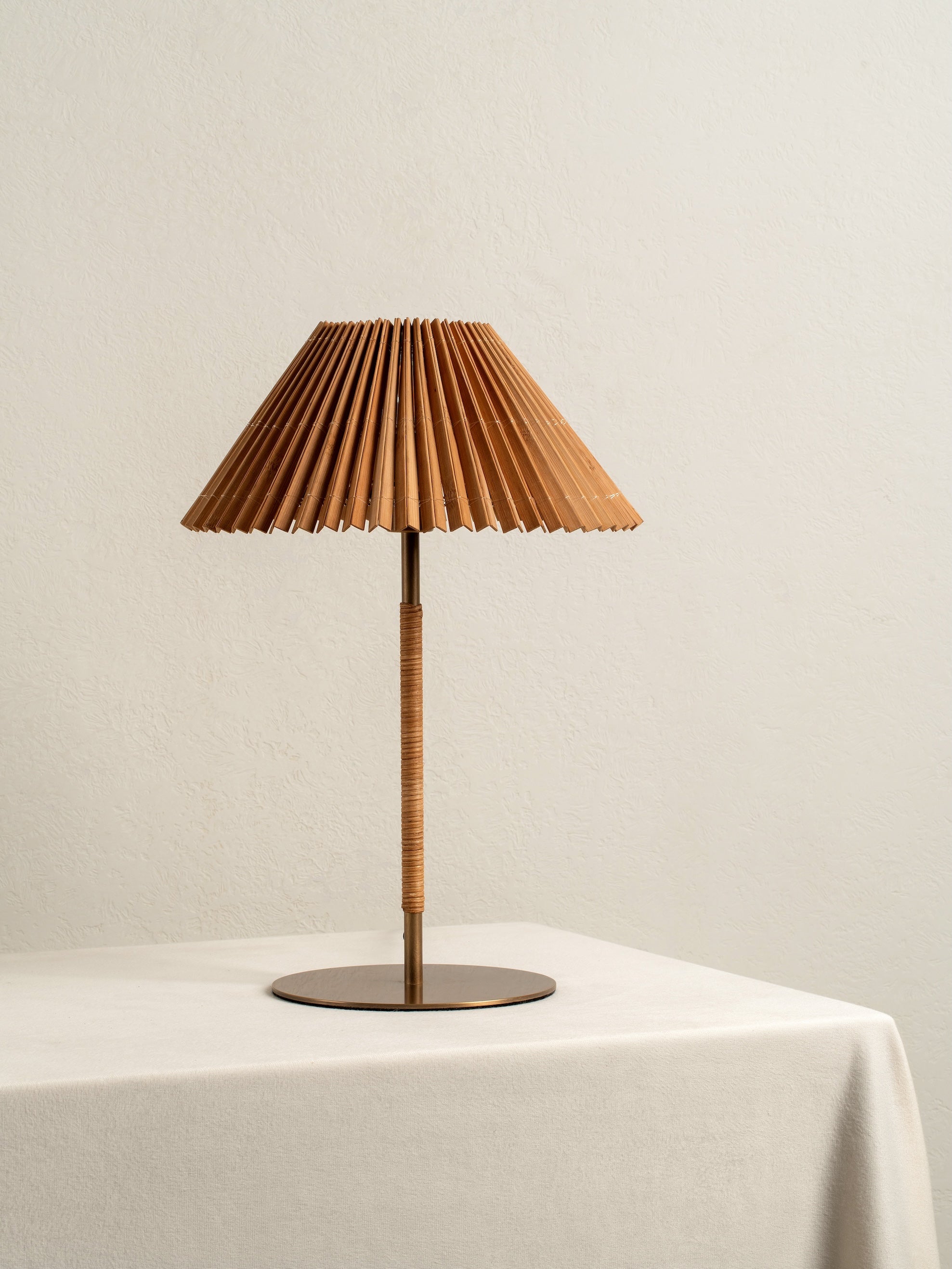 Table lamp with pleated brown shade on a white surface