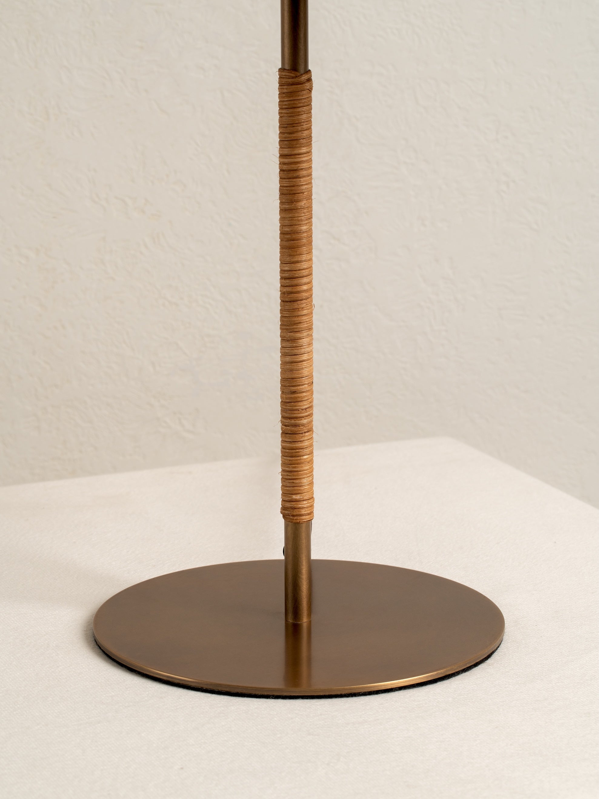 Bronze stand with woven design on a white background