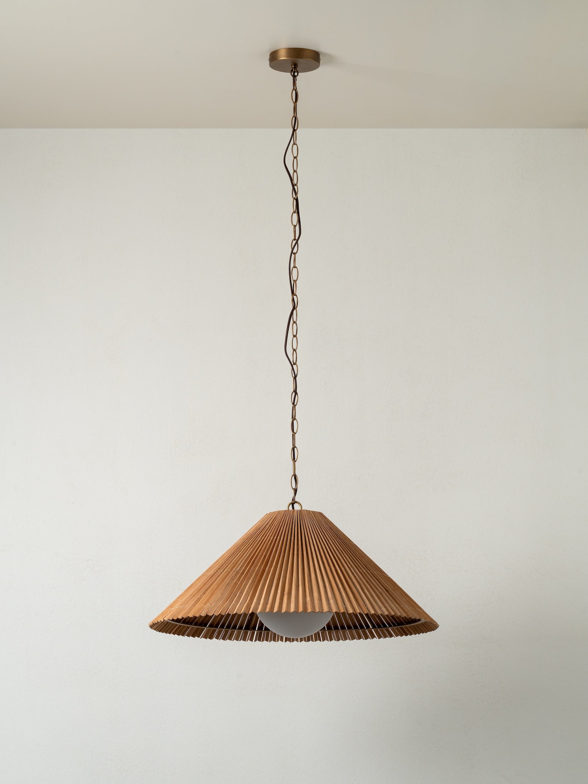 Wooden pendant light hanging against a plain wall