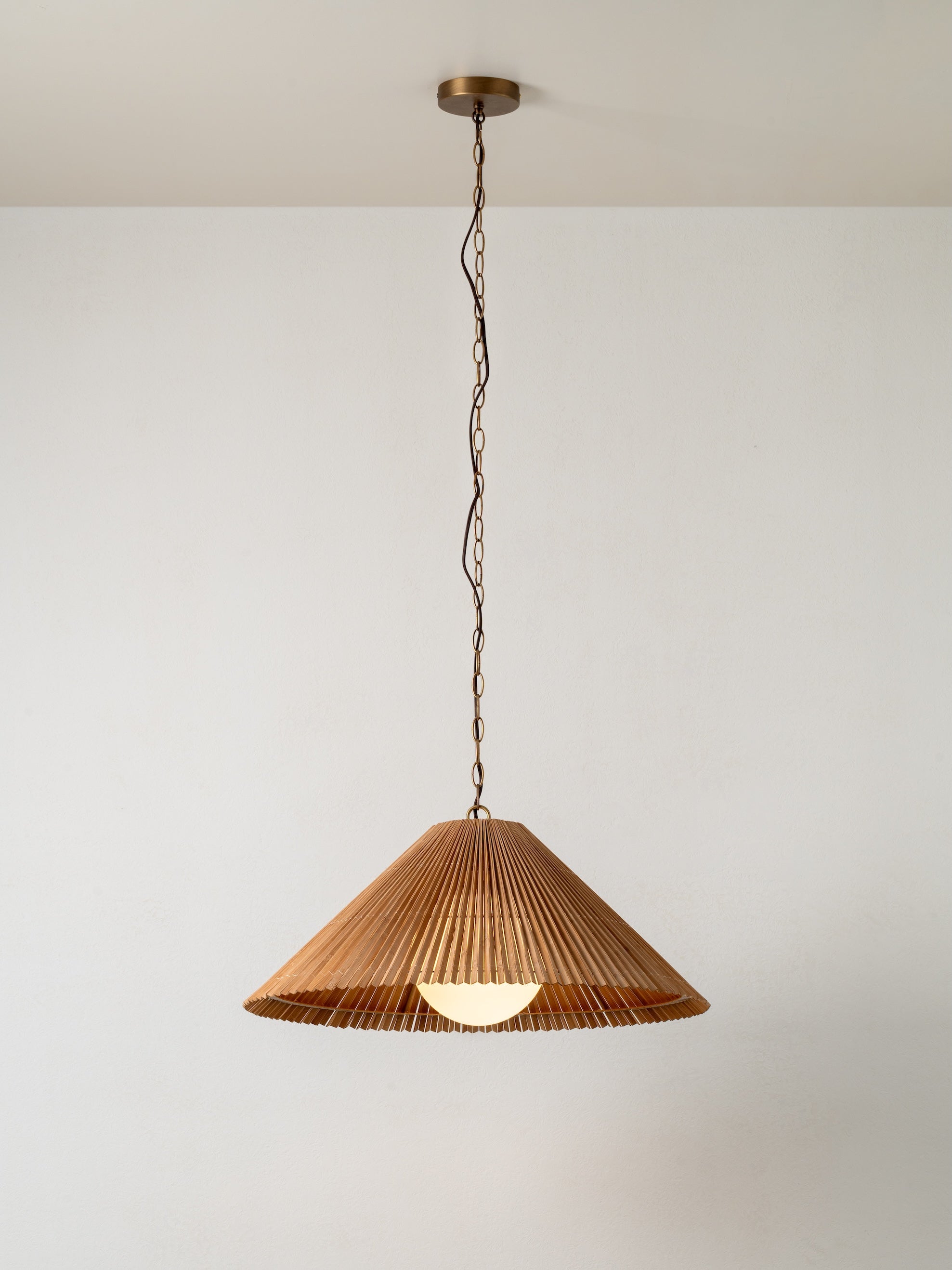 Pendant light with wicker shade on a plain background