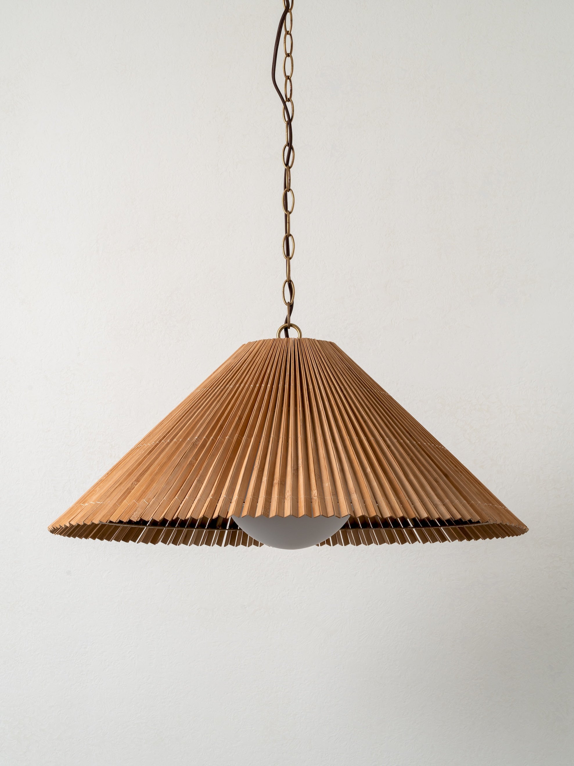 Wooden pendant light with pleated design on a plain background