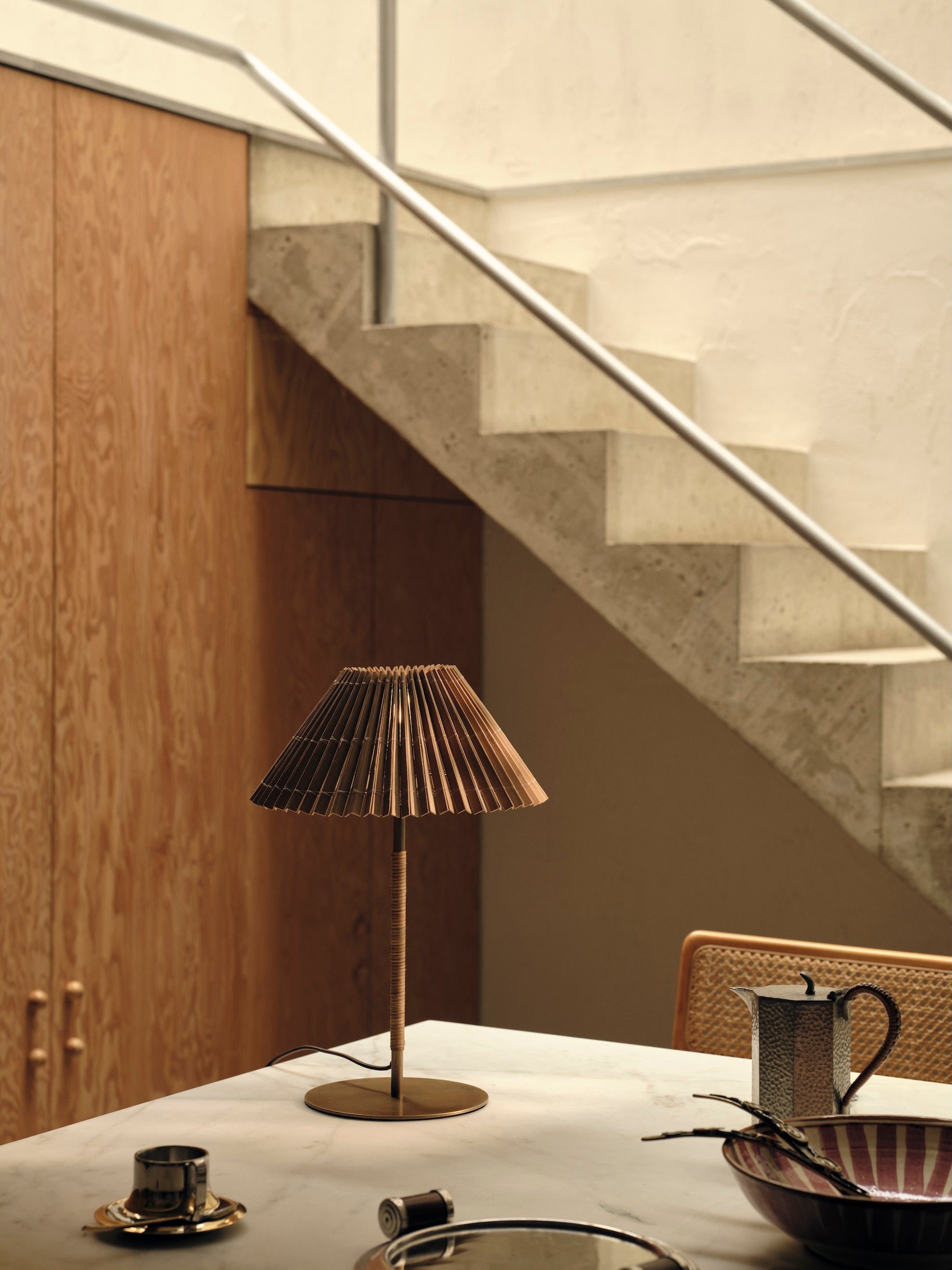 Bronze table lamp on a table with a staircase in the background