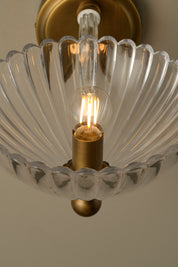 Light fixture with clear glass shade and gold metal base