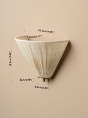 A pleated cone-shaped wall sconce in an off-white/cream tone, shown with dimension lines and text indicating its height, width, and depth on a plain beige background.