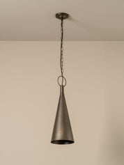 A single pendant light with a dark bronze metal cone shade hanging from a matching ceiling canopy and chain against a plain beige wall.