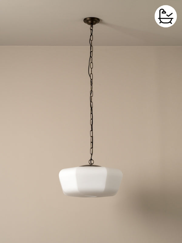 White pendant light hanging from a chain against a beige wall.