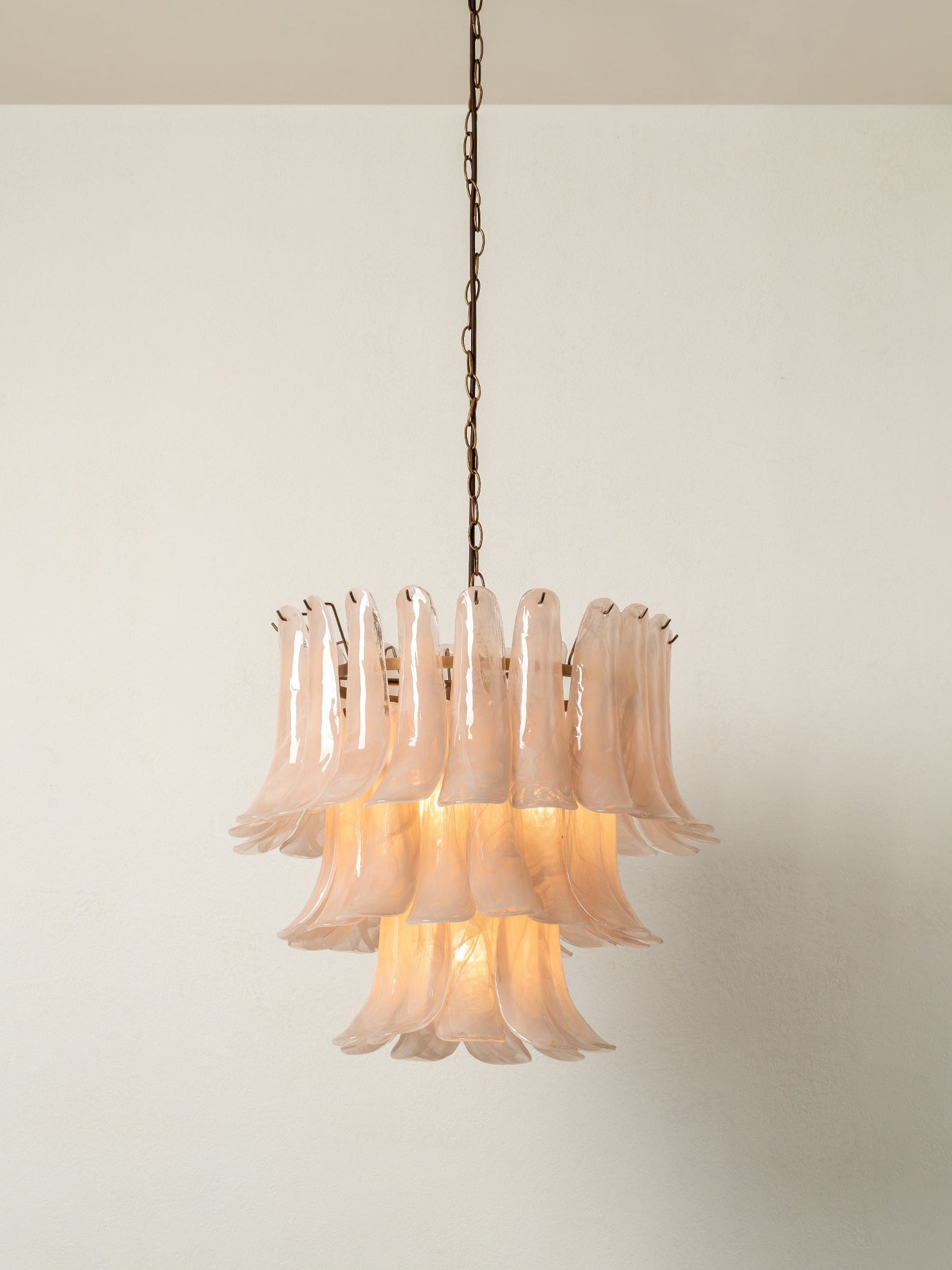 Chandelier with pink glass shades on a beige wall