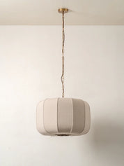 Beige pendant light hanging against a plain white wall