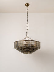A modern tiered chandelier with a bronze-finished metal frame and hanging glass shades, suspended from a ceiling by a chain.